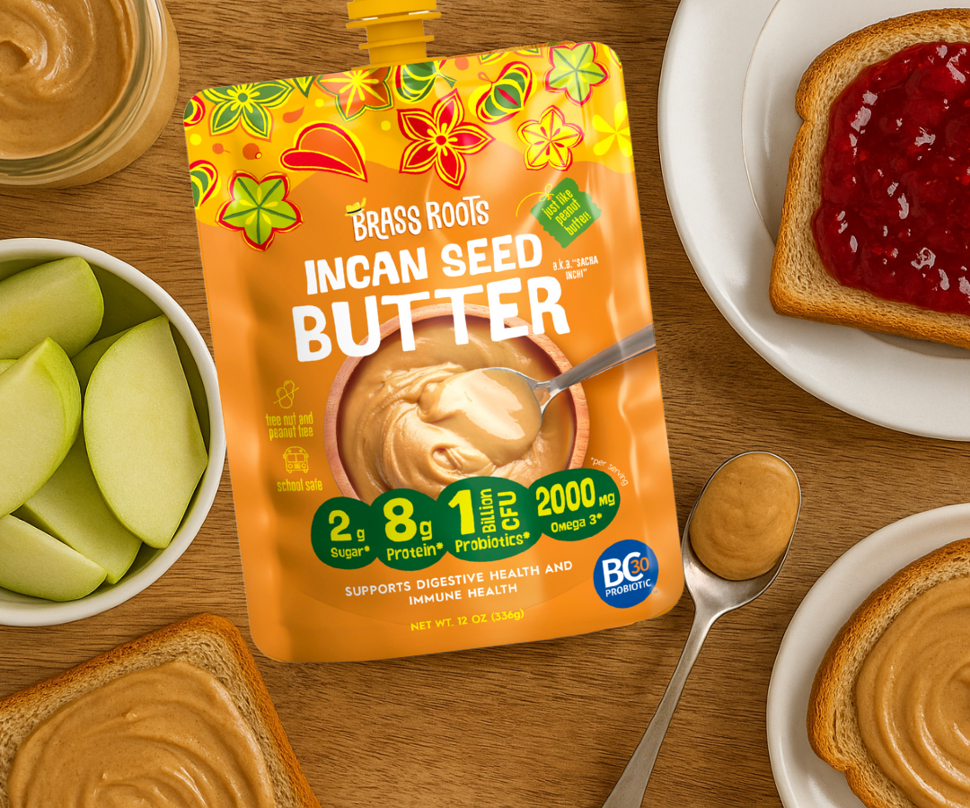 A pouch of Incan Seed Butter with illustrations of seeds and nuts, accompanied by sliced apples and a spoon with peanut butter on a wooden surface.